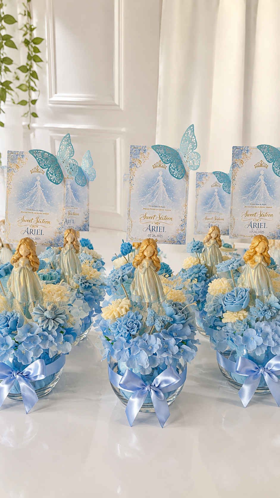 Blue floral candle centerpieces with butterflies and Sweet Sixteen cards