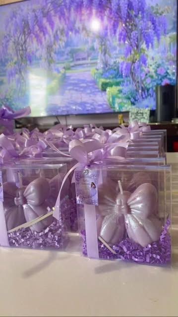 Princess and diamond candle favors presented on a decorated platform in clear boxes