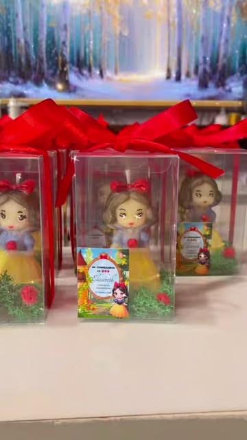 Snow White-inspired candle favors in clear boxes with red ribbon