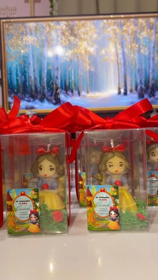 Snow White-inspired candle favors in clear boxes with red ribbon
