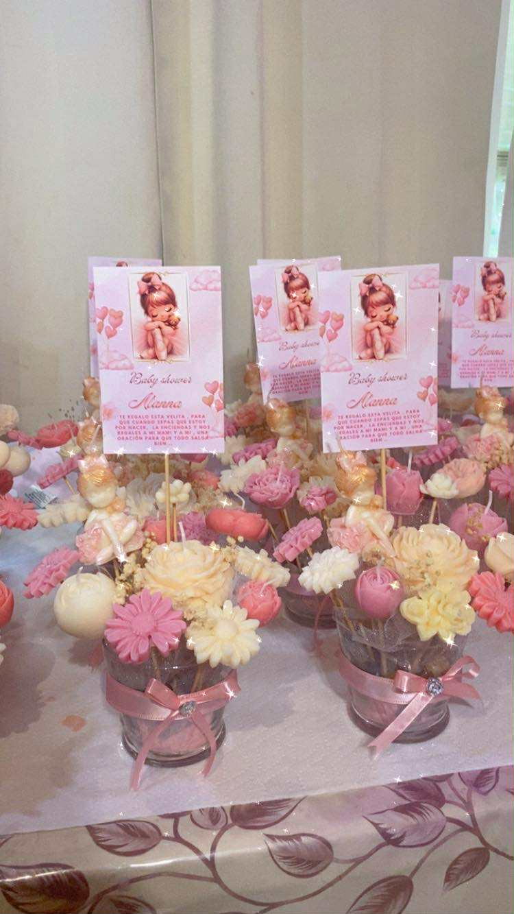 Baby shower centerpieces with pink and cream flower candles and pink baby cards