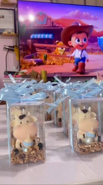 Little cow candle favors in clear boxes with bows