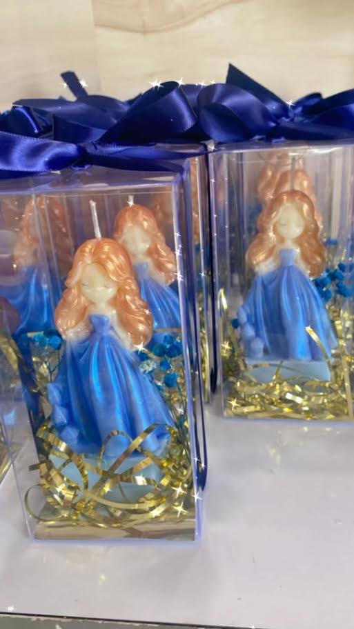 Princess and diamond candle favors presented on a decorated platform in clear boxes