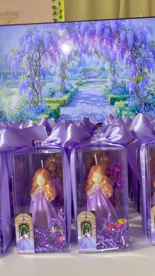 Princess and diamond candle favors presented on a decorated platform in clear boxes